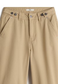 Pantalones de algodón beige con cremallera, cierre de doble botón y bolsillos frontales. Presentan una textura suave y un diseño de corte recto.