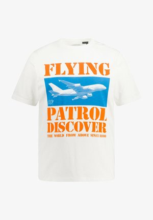 T-shirt en coton blanc avec un texte orange audacieux : "PATROUILLE VOLANTE DÉCOUVRIR." Graphique d'un avion sur un fond bleu. Manches courtes, coupe décontractée.