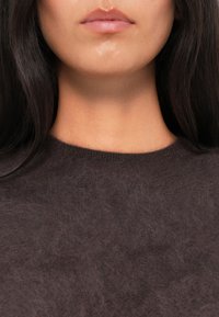 Maglione a maglia morbida di colore marrone scuro, con scollatura a girocollo. Tessuto morbido con una vestibilità leggermente ampia intorno al collo e finitura liscia.