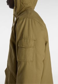 Olive green hooded jacket with a textured fabric, featuring a side pocket and a drawstring. The design includes reinforced seams and a relaxed fit.