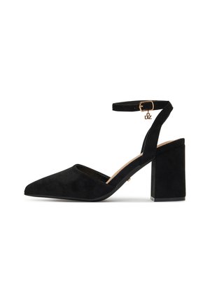 Escarpins en daim noir à talons avec un bout pointu, une bride à la cheville, et un talon carré. Ils sont dotés d'une boucle dorée en guise de fermeture.