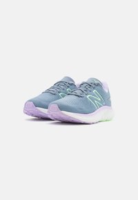 Jasnoniebieskie buty sportowe z fakturowaną siateczką, zielonymi akcentami i fioletową podeszwą. Wyróżniają się amortyzującą podeszwą środkową dla komfortu.