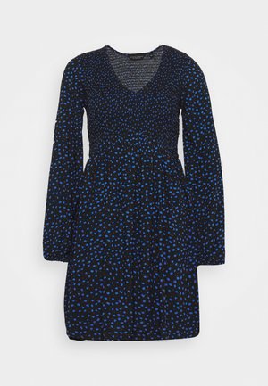 Musta mekko, jossa on sinisiä pilkkuja, pitkät hihat ja v-mallinen pääntie. Mekossa on resoroitu vartaloosa ja leikattu vyötärö, kevyt kangas.