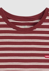 T-shirt rayé bordeaux avec des lignes horizontales blanches, un col rond et une étiquette du logo rouge Levi's sur le bas à gauche. Matière en coton.