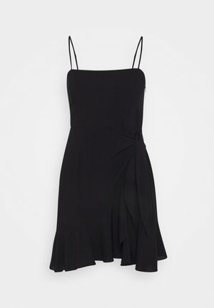 Robe noire avec bretelles fines, corsage ajusté, détail noué à la taille et ourlet évasé orné de volants. Tissu doux à la texture lisse.