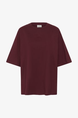 Camiseta oversize de manga corta en color burdeos oscuro, con cuello redondo y pequeño logo en relieve centrado en el pecho.