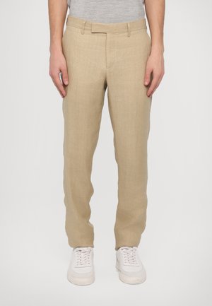 Beige linnedrejede bukser med lige pasform, med flad front, bælteholdere og en glat tekstur. Sæt med hvide sneakers.