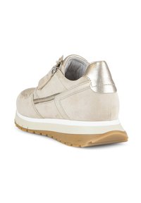 Béžová semišová teniska s kovově zlatou patou, bočním zipem, bílou stélkou a hnědou gumovou podrážkou, pohled zezadu z pravého úhlu.