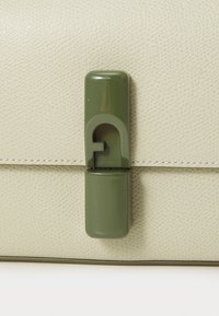 Light green textured leather bag featuring a glossy olive green hardware clasp. The bag has a clean, minimalist design with visible stitching.