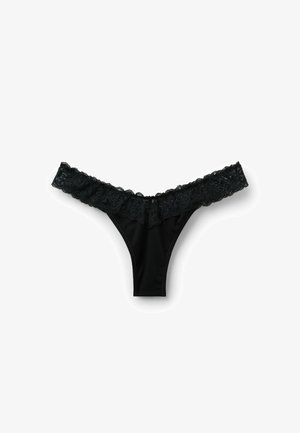 Black thong made of smooth fabric with a wide lace trim along the waistband, featuring intricate floral patterns and scalloped edges.