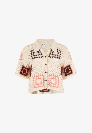 Cardigan all'uncinetto color crema con maniche corte, caratterizzato da motivi quadrati in marrone scuro, rosa e pesca. Bottoni evidenti e finitura texture.