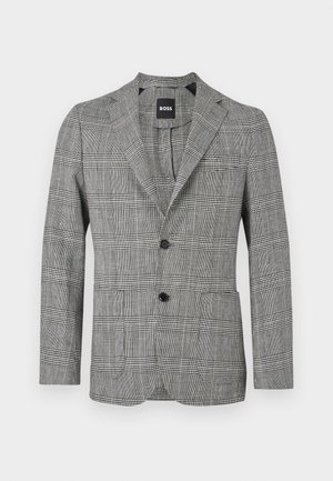 Meeste musta-valge ruuduline bleiser kahe musta nupuga ja särklae valge taustaga.