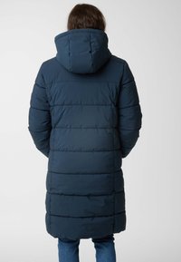 Gevoerde lange jas in marineblauw met een capuchon, met horizontaal doorgestikte panelen en een gladde textuur. De achterkant toont de lengte van de jas.