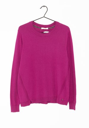 Pull à manches longues en magenta vif, en maille, col rond, poignets et ourlet côtelés, avec un détail de couture latérale. Suspendu à un crochet noir.