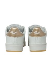 Un paio di sneaker bianche basse con dettagli dorati sul tallone e un logo bianco su ciascun linguetta del tallone, viste da dietro.