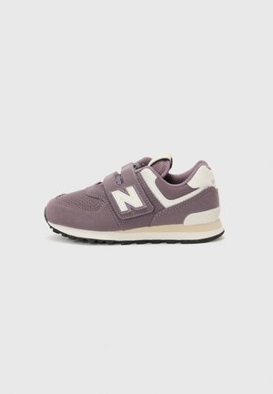 Lila sneaker tépőzárral, hálós és velúr anyagból, fehér kiemelésekkel, texturált felülettel és alacsony profilméretű fekete talppal.