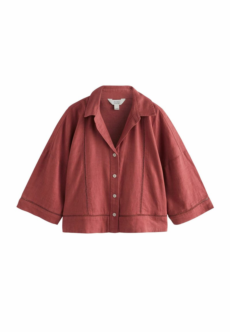Chemise rouge en lin à manches courtes avec col, fermeture à boutons et couture décorative sur le devant et les manches.