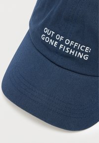 Cappellino da baseball blu navy in cotone, con scritta ricamata bianca "OUT OF OFFICE! GONE FISHING" sulla parte anteriore. Visiera curva.