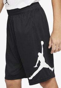 Shorts deportivos negros de tela de malla, con un logo de Jumpman blanco en la pierna izquierda y una cinturilla elástica para un ajuste seguro.