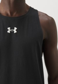 Débardeur noir sans manches en matière douce, avec un logo Under Armour blanc sur la poitrine, doté d'un col rond et d'une coupe décontractée.