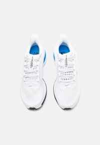 Pantofi sport albi cu accente albastre și negre, superior din plasă, vârf rotund și sistem de șireturi tradițional. Logo-ul Nike pe lateral.