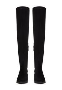 Botas de ante negras hasta la rodilla con una textura suave, silueta esbelta y cremalleras laterales. Suelas planas resistentes.