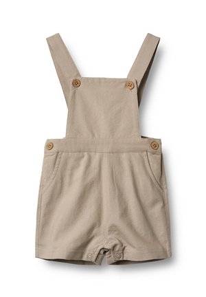Monos de algodón beige con tirantes ajustables, dos bolsillos frontales, botones de madera y un diseño corto. Textura suave, estilo casual.