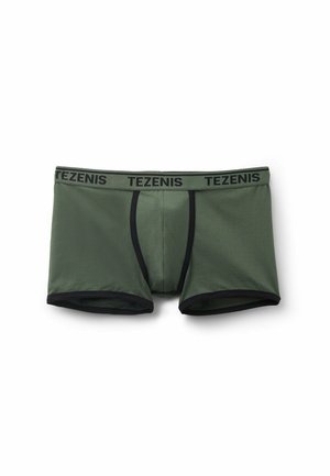 Dunkelgrüne Baumwoll-Boxershorts mit einem schwarzen elastischen Bund, der das "TEZENIS"-Logo trägt. Glatte Textur und figurbetontes Design.
