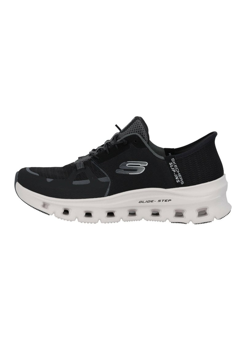 Chaussure de sport noire avec une tige en mesh léger, un design à lacets et une semelle blanche rembourrée avec des découpes pour la respirabilité.