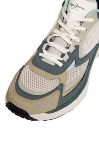 Baskets avec tige en mesh et daim de couleurs vert, beige et gris. Dotées de lacets blancs, d'accents cousus et d'une semelle texturée.