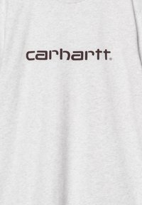 Camiseta de algodón gris con un logo "carhartt" marrón oscuro centrado en el pecho, con un acabado de tela suave y texturizada.