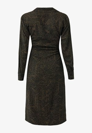 Vestido negro de manga larga, hasta la rodilla, con un patrón geométrico de líneas beige que forman formas irregulares, visto desde atrás.