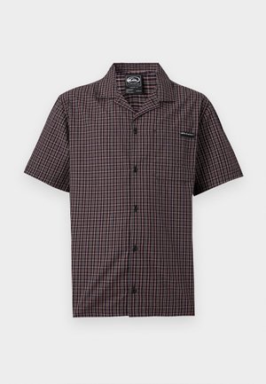 Kortermet skjorte med knapper foran, mørkt rutemønster, spredt krage og liten brystlomme mot ensfarget bakgrunn.