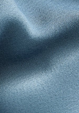 Hele sinine kangas, millel on sile tekstuur ja peene, ühtlane kudumise muster, mis viitab pehmele ja kergele materjalile.