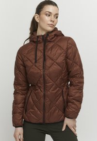 Veste matelassée marron avec un design en losange, capuche ajustable et fermeture éclair noire. Elle dispose de poches latérales et d'une texture élégante.