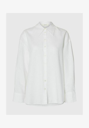 Bílá košile s dlouhým rukávem a knoflíkovou légou, s špičatým límcem a knoflíky vpředu, zobrazena na neutrálním pozadí.