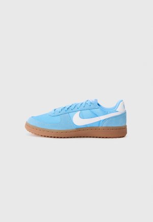 Lyseblå Nike sneaker med hvid swoosh-logo og brun gummisål, vist fra siden på en ensfarvet lys baggrund.