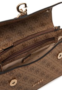 Borsa marrone con motivo, caratterizzata da un clasp con logo dorato e tasche interne con zip. L'esterno ha una finitura testurizzata con una fodera liscia.