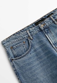 Jeans av denim med en ljusblå tvätt, med knappgylf, flera fickor och kontrasterande sömmar. Mjuk textur med lätt blekning.