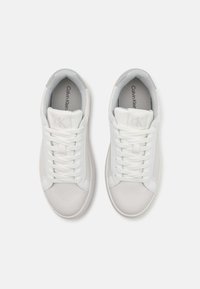Hvite lær sneakers med glatt tekstur, snøring og subtil merkevare på tungen. Gummisåle med avrundet tåform.