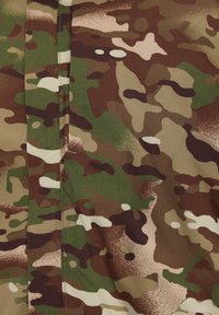 Kamouflagematerial som har en blandning av gröna, bruna och beige fläckar. Texturerad yta med en mjuk finish och distinkta mönstervariationer.