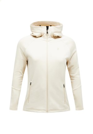 Giacca zip-up di un beige chiaro con colletto alto, maniche raglan e due tasche laterali dotate di cerniere nere. Tessuto liscio e elastico.