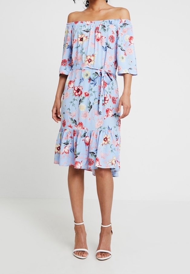 Blumenkleid mit schulterfreiem Schnitt in Hellblau, tailliertem Bund, weit ausgestelltem Saum und mit Rüschendetails. Es ist mit lebhaften roten und pinken Blumen gestaltet.