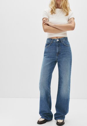 Hoge taille blauwe denim jeans met wijde benen, voorzien van vijf zakken en een knoopsluiting aan de voorkant. Draag het met een cropped wit topje.