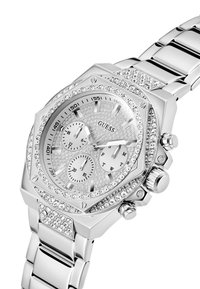 Montre Guess argentée avec un cadran texturé, trois sous-cadrans et une lunette ornée de cristaux. Dotée d'un bracelet en maillons métalliques polis.