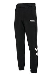 Pantalones de chándal negros Hummel con cintura y puños elásticos, logo blanco en el muslo izquierdo y dos chevrones blancos en la parte inferior de la pierna derecha.