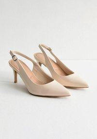 Décolleté slingback in vernice beige con punta affilata, tacco alto circa 7 cm e cinturino regolabile con fibbia.
