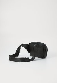 Geantă crossbody din piele sintetică neagră, cu o suprafață texturată, curea ajustabilă, închidere cu fermoar și o formă compactă, dreptunghiulară.