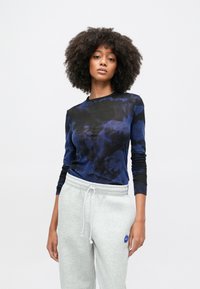 Πουκάμισο με μακριά μανίκια σε σκοτεινό μπλε και μαύρο μοτίβο tie-dye, κατασκευασμένο από μαλακό ύφασμα, σε συνδυασμό με ανοιχτό γκρι φόρμα με ελαστική μέση.