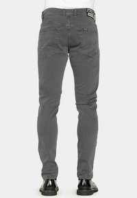 Jeans in cotone grigio con una vestibilità slim, design a cinque tasche e dettagli di cucitura sottili. Finiti con una toppa in pelle sulla vita.